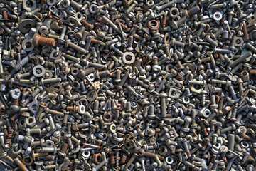 Metal steel gray rusty bolts, nuts, screws and screws are lying on the floor. Fasteners and hardware for repair