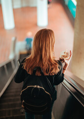woman coffee going down escalators miami Brickell subway  