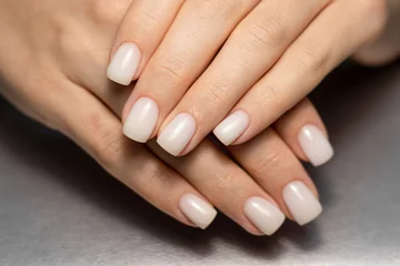  Beautiful nude manicure. Short square nails. Nail design. Manicure with gel polish. Close-up of the hands of a young woman with a delicate nude manicure on her nails. Elegant nails with gel polish.  © Alina