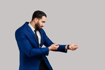 Side view of bearded man looking diligent and strong, standing in attack or pulling hands gesture...