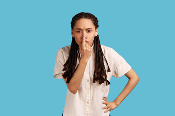 You are liar. Portrait of serious woman with black dreadlocks standing with finger on her nose and...