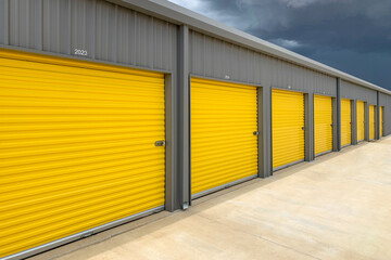 Exterior of a commercial warehouse with yellow roller doors, garages, self storage facilities
