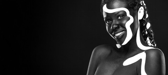 The Art Face. Black and white body paint on african woman. Abstract creative portrait. Bright...