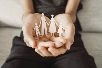 Hands holding paper family cutout, family home,life insurance, adoption foster care, homeless support , mental health, homeschooling education, Autism support, parent day - 535361213