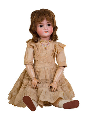 Isolated antique jointed sitting doll a linen dress