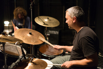 Fototapeta na wymiar Drummer in rock band recording music in the professional recording studio