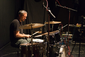 Fototapeta premium Drummer in rock band recording music in the professional recording studio