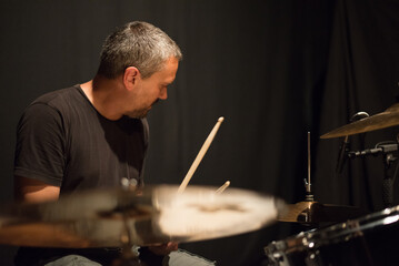 Drummer in rock band recording music in the professional recording studio