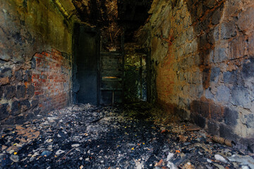 Burnt building interior. Ruined walls in black soot. Consequences of fire