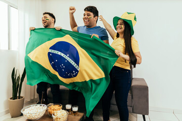 Football fans friends watching Brazil national team in live soccer match on TV at home