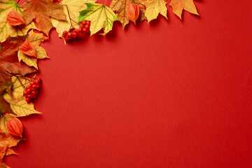 Autumn background. Maple leaves corner on red background.