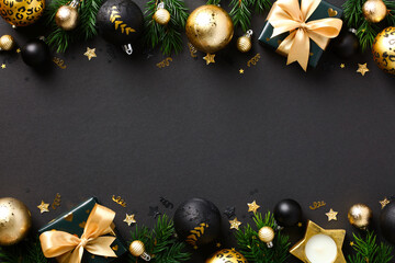 Black Christmas background with luxury decorations, golden balls, gift boxes, fir branches. Xmas...