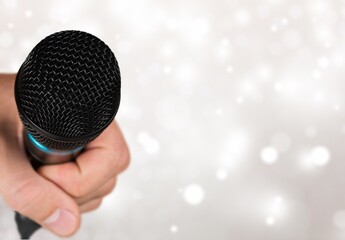Classic black microphone with stage lighting background