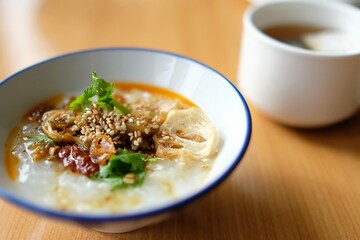 A bowl of Japanese rice porridge with traditional condiments at a Narita airport hotel breakfast buffet
