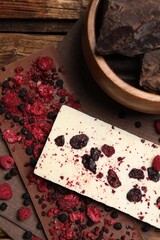 Fototapeta na wymiar Different chocolate bars with freeze dried fruits on wooden table, flat lay