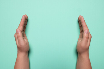 Woman holding on turquoise background, closeup of hands. Space for text