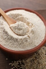 Fototapeta na wymiar Quinoa flour in bowl and seeds on wooden table