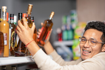 Man looking at camera while buying bottles of alcohol