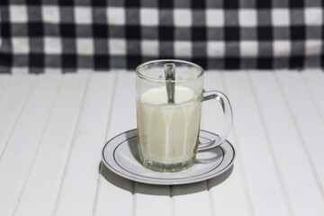 A glass of healthy milk on white wooden background