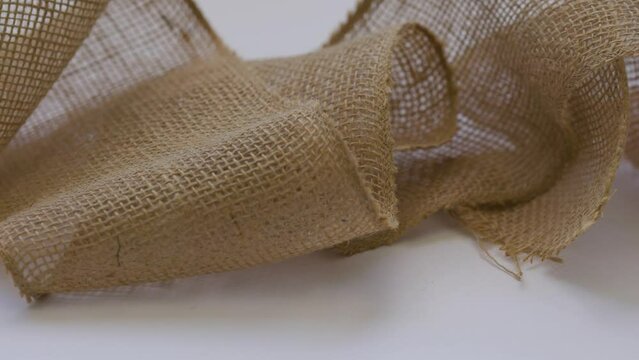 Sliding in front of a stripe of loose hemp fabric on white background