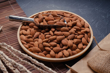 Roasted Delicious Almond on brown wooden table, Almond in wooden plate on wooden table.