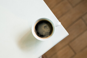 hot coffee on a table with cream being poured into it showing the texture