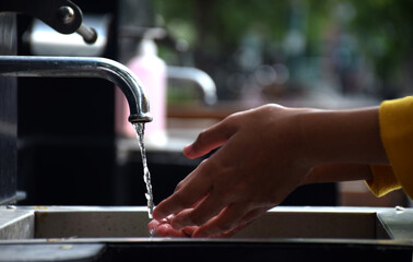 washing hands in the sink in public places, to maintain cleanliness to avoid covid-19