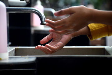 washing hands in the sink in public places, to maintain cleanliness to avoid covid-19