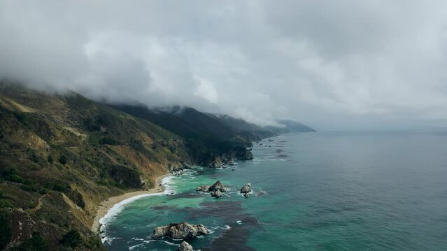 Natural Aerial drone flying over Big Sur California coast beach cloudy fog the ocean clouds sky sun sunny waves crashing. Travel view scene peak weather wave. High quality 4k footage.