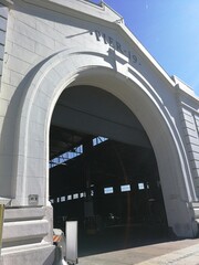 Sunkissed building entrance arch, shadowplay, white building. Seaside structure. 