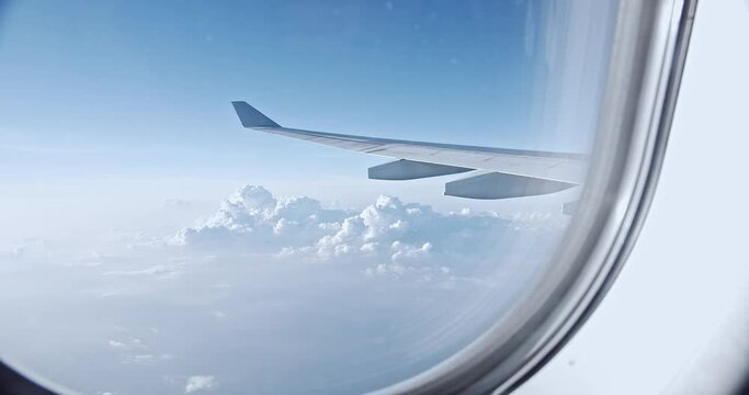 Aerial view of cloudscape and sky through airliner window in the morning