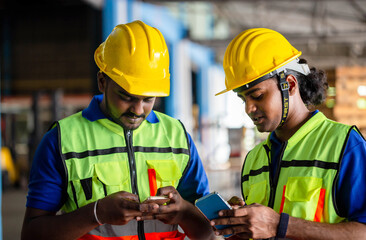 Manual workers working in warehouse talking about job, Warehouse worker in the hard hat uses mobile phone, Men using smartphone