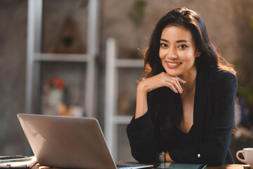 Professional Asian business woman using computer laptop to work on cyberspace communication technology in cafes, happy young beautiful and attractive businesswoman in modern lifestyle