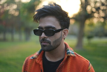 young man wearing jacket walking in park