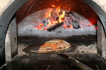 calzone saindo do forno a lenha