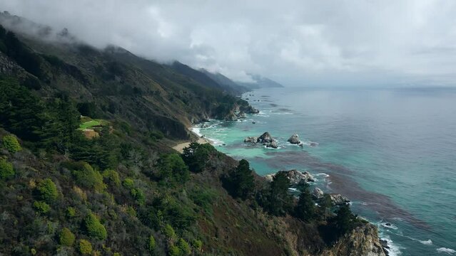 Natural Aerial drone flying over Big Sur California coast beach cloudy fog the ocean clouds sky sun sunny waves crashing. Travel view scene peak weather wave. High quality 4k footage.