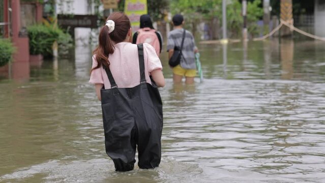 Video flooding, flooding, people carrying goods. flooded housing, Meng District, Thailand, on October 3, 2022, is a photograph from real flooding. With a slight color adjustment