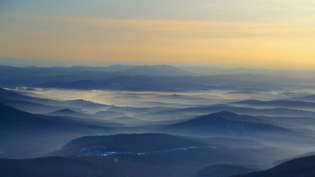 Colorful mountain hills with tonal perspective at winter evening at sunset. Abstract panoramic landscape in Gornaya Shoria, Sheregesh ski resort in Russia Foggy Mountains nature background