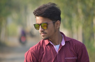 Man in red button up shirt wearing gold framed aviator sunglasses