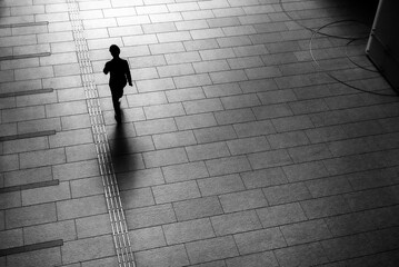 Man walking on gray brick floor