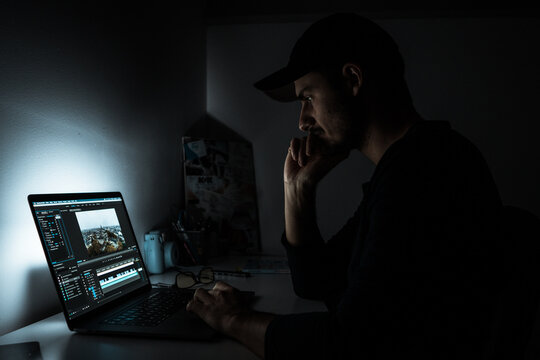 Man Using Laptop Computer In A Dark Room