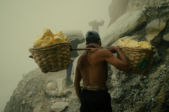 Minners carrying sulfur on top of Kawah ijen through toxic fumes