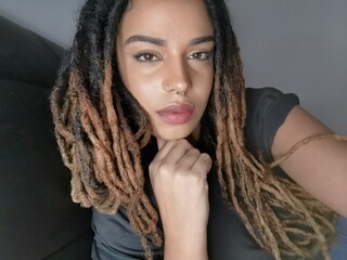 Portrait of woman with hair dreads and nose piercing indoors
