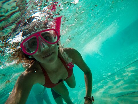 Woman in blue swimming goggles and green bikini top