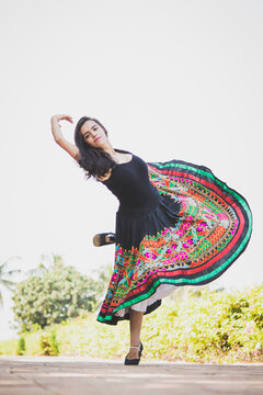 Woman in colorful skirt dancing outdoors