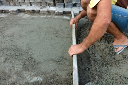 Worker leveling the foundation with a wooden board