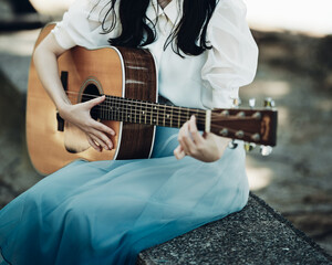 アコギを弾く女性の手元