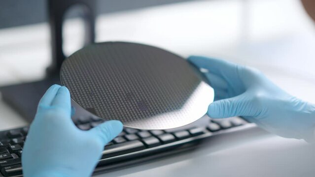 midage chinese technician researching semiconductor wafer in library