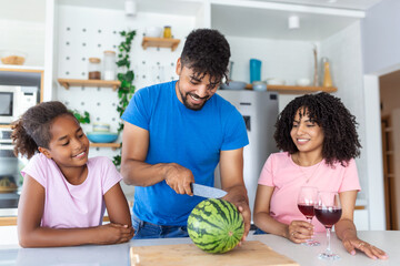 Family of three. Happy young family enjoying a watermelon. Family eating a watermelon slice and laughing together.