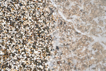 Pebbles on the beach. Black Sea. Beach with colorful rocks. Pebble by the sea. Background from stones. Wave and pebble.